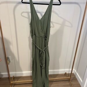 Olive green neck jumpsuit with tie waist and pockets.